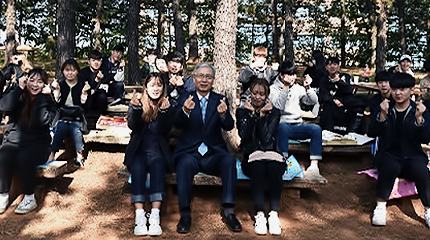 산에 앉아서 포즈 취하고 있는 교수와 학생들 사진